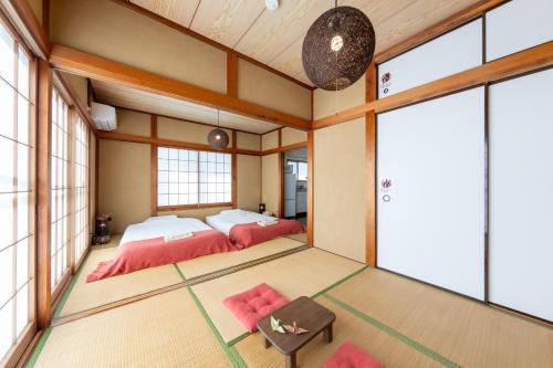 a bedroom with two beds in a room with windows at Coto House Kamakura RoomA in Kamakura