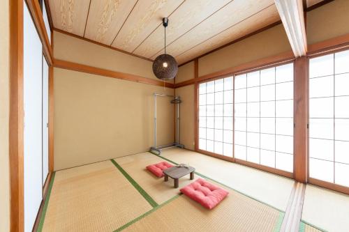 an empty room with pink furniture and large windows at Coto House Kamakura RoomA in Kamakura