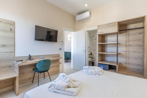 a bedroom with a bed with a desk and a chair at Dimora Suite Idro in Gallipoli
