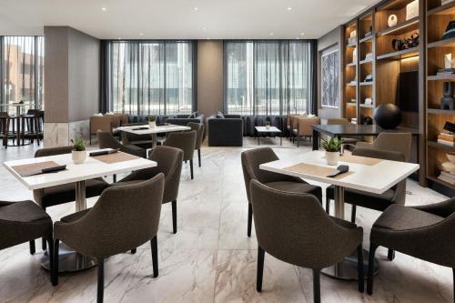 a restaurant with tables and chairs and windows at AC Hotel by Marriott Ann Arbor Downtown in Ann Arbor