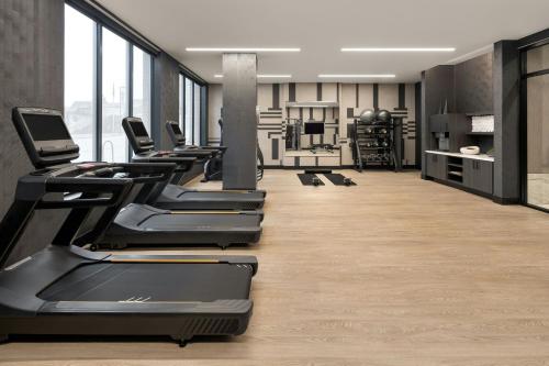 a gym with a row of treadmills and machines at AC Hotel by Marriott Ann Arbor Downtown in Ann Arbor