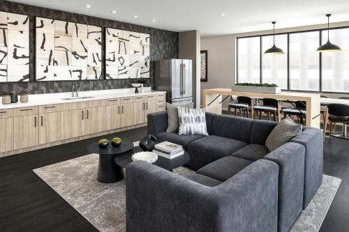a living room with a couch and a kitchen at AC Hotel by Marriott Ann Arbor Downtown in Ann Arbor
