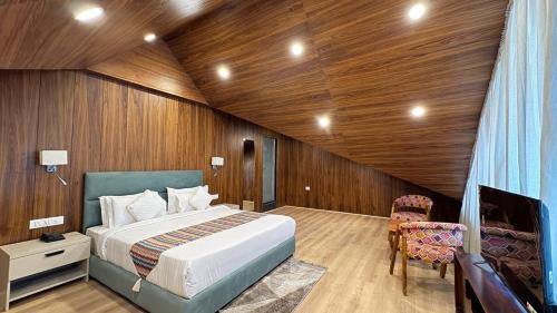 a bedroom with a bed and a wooden wall at Emroz Kings Resort in Batakūt