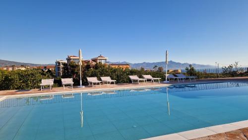 a large swimming pool with lounge chairs andermottermottermott at Lumia in Riposto