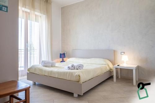 a bedroom with a bed and a large window at Hotiday Gallipoli Lungomare in Gallipoli