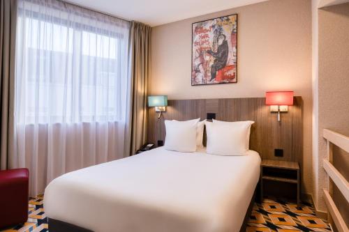a hotel room with a large bed and a window at ALMA Grand Place Hotel in Brussels