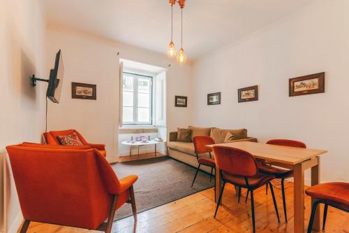 a living room with a table and chairs at Portas da Sé Apartments in Lisbon
