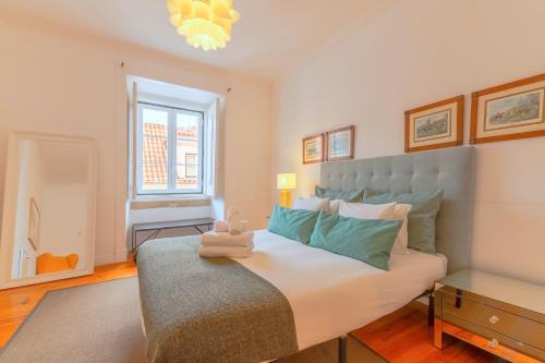 a bedroom with a large bed and a window at Portas da Sé Apartments in Lisbon