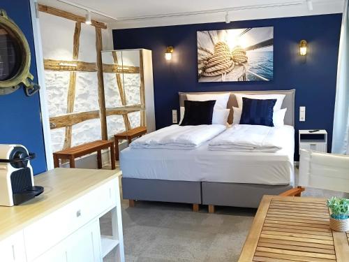 a bedroom with a bed with a blue wall at NOX HOTEL - Digital-Check-In - No Reception - nahe Bretten & Karlsruhe - 2 Nautic in Wössingen