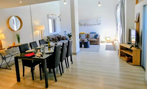 a dining room and living room with a table and chairs at Appartement 3 chambres - 100m2 - Jacuzzi in Les Deux Alpes