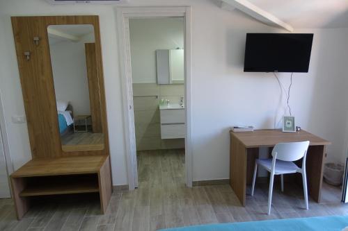 a room with a desk and a tv and a mirror at MaMo B&B in Nocera Terinese