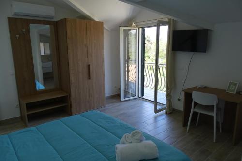 a bedroom with a bed and a desk and a window at MaMo B&B in Nocera Terinese