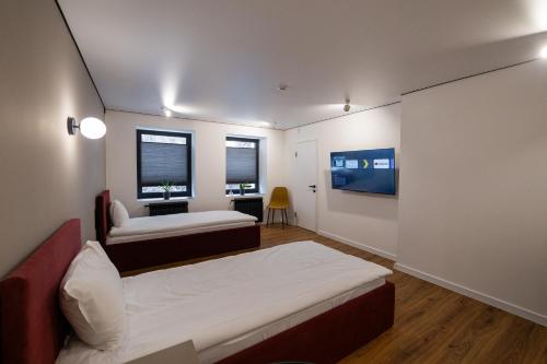 ein Zimmer mit zwei Betten, einem Schreibtisch und zwei Fenstern in der Unterkunft N17 Hotel in Poltawa