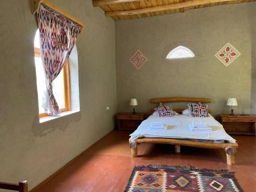 a bedroom with a bed and two windows at Shirin Ethno House Yurt Camp in Shirin