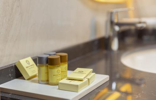 four bottles of oils sitting on a shelf in a bathroom at Dinler Hotels Urgup in Ürgüp