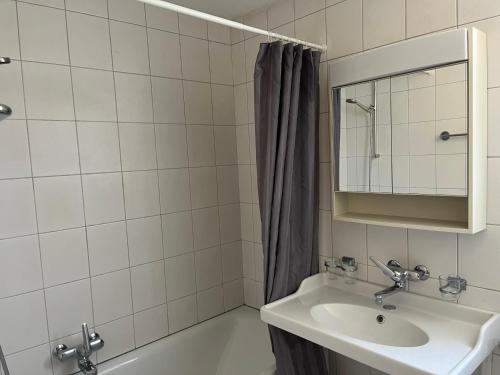 a bathroom with a sink and a mirror and a tub at 1 bed flat in central Zug in Zug