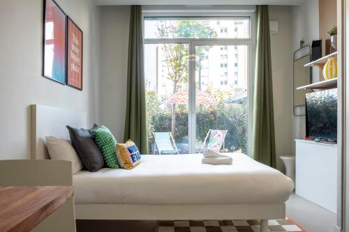 a bed in a room with a large window at Appart'hôtel Toulouse Zénith in Toulouse