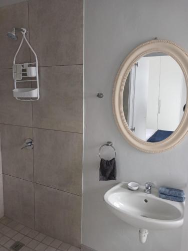 a bathroom with a sink and a mirror at EBB Tide Guesthouse in Velddrif