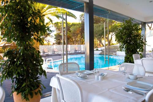 a table with a white table cloth and chairs and a pool at Amazonia Estoril Hotel in Estoril