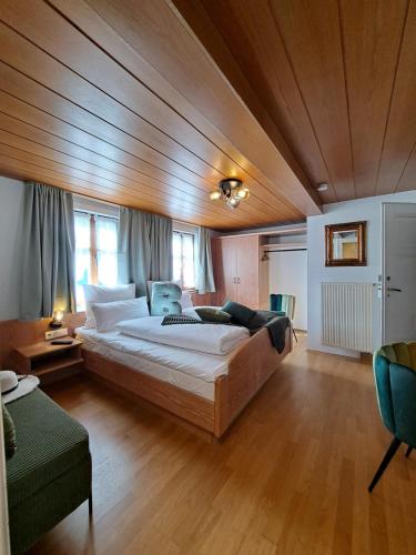 a large bed in a room with a wooden ceiling at Hotel Bezold in Rothenburg ob der Tauber