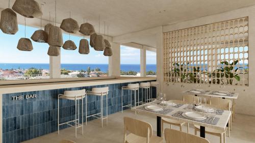 ein Restaurant mit Tischen und Stühlen und Meerblick in der Unterkunft Captains De Luxe in Argassi