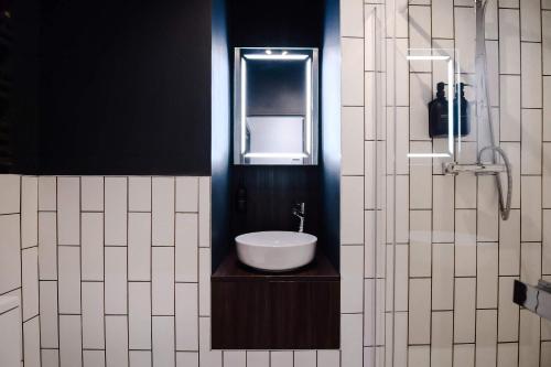 a bathroom with a sink and a mirror at Stylish Northern Quarter Studio, Ideal for Leisure & Work Stays in Manchester
