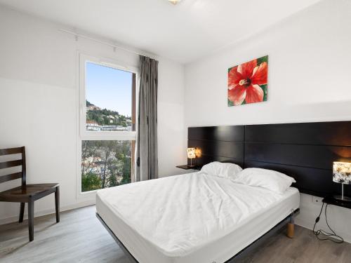 a white bedroom with a large bed and a window at Virginia N213 - 2p4 in Grasse