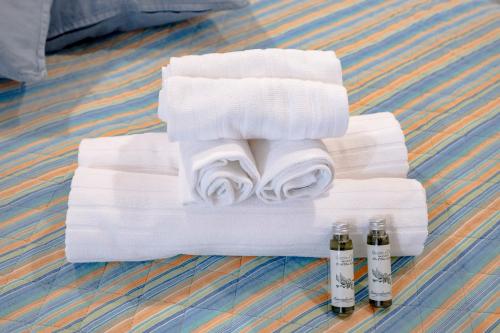 a stack of towels with three bottles of alcohol at Case D'Amare - Tritone 30 in Polignano a Mare