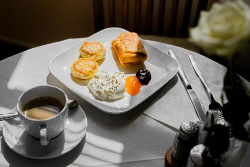 a plate of pastries and a cup of coffee on a table at Villa Walir - Spa Hotel Garni SUPERIOR in Mariánské Lázně