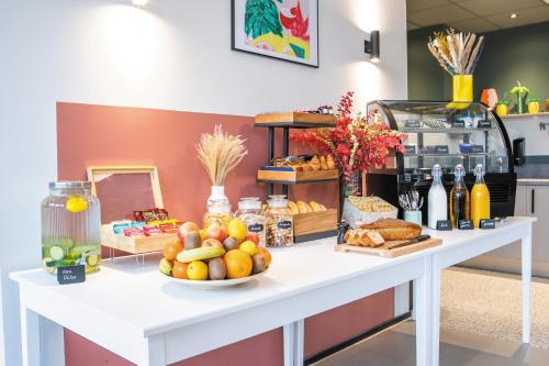 a table with fruits and vegetables on top of it at Appart'hôtel Toulouse Zénith in Toulouse