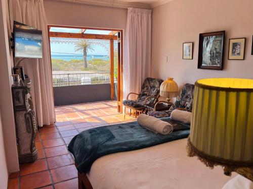 a bedroom with a bed and a view of the ocean at Goblin's Inn in St. Helena Bay
