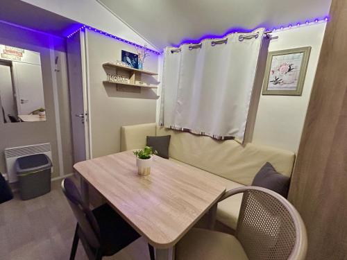 a table and chairs in a room with purple lights at Tiny Home Strandkoje 823 in Göhren