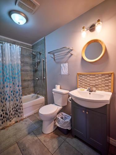 a bathroom with a sink and a toilet and a shower at Four Seasons Algonquin Cabins in Madawaska