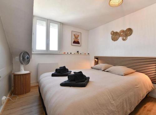 a bedroom with a large bed with black towels on it at Au pays des bretzels in Horbourg