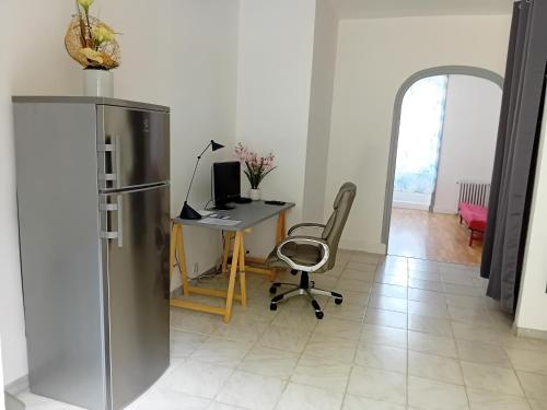 a desk with a computer and a chair in a room at Appartement avec terrasse 53m2 in Saint-Martin-de-Valamas