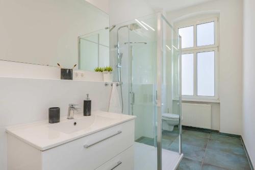 a white bathroom with a sink and a shower at Villa Tanneck App 1 in Ahlbeck