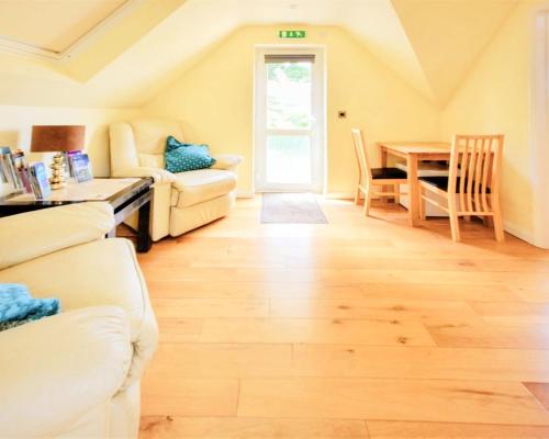 a living room with white furniture and a table at Hunter Heights Loft – Near Ventnor, Isle of Wight in Wroxall