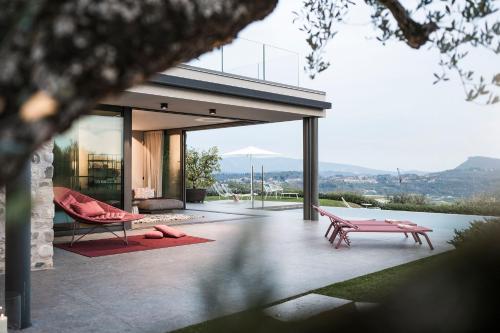 a house with two pink benches on a patio at Villa La Biancolilla in Garda