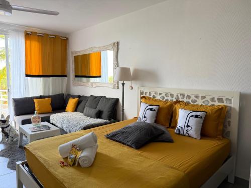 a bedroom with a large bed and a couch at Residence Anse des sables in Marigot