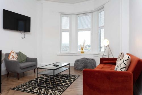 a living room with a couch and a table at The Fairlie Suite No1 in Prestwick