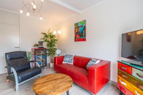 a living room with a red couch and a table at Californiëweg 9A in De Koog