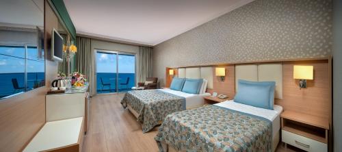 a hotel room with two beds and a view of the ocean at Royal Garden Beach Hotel in Konaklı