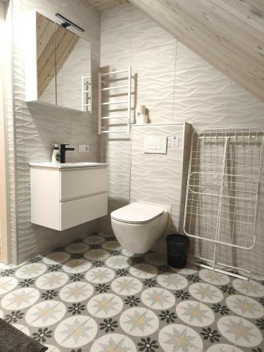 a bathroom with a toilet and a sink and a mirror at Loft Apartment Self Check-in in Mažeikiai