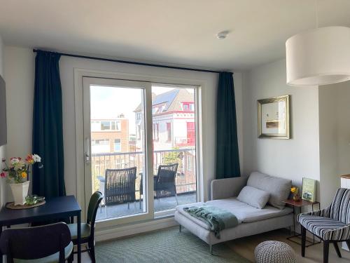 a living room with a couch and a large window at Strandhuis Scheveningen - Studio Apartments in Scheveningen