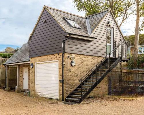 a large house with a garage and a staircase at Hunter Heights Loft – Near Ventnor, Isle of Wight in Wroxall