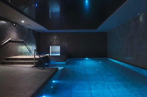 a swimming pool with blue lights in a room at The Kinmel & Kinspa in Abergele