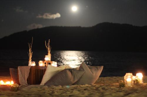 a table on the beach at night with the moon at BuBu Villa in Perhentian Island