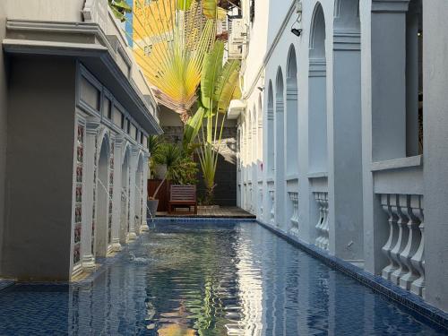 an alley with a pool of water between two buildings at Museum Hotel in George Town