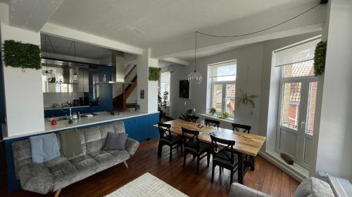 a living room with a couch and a table and chairs at Maro Appartments in Ieper