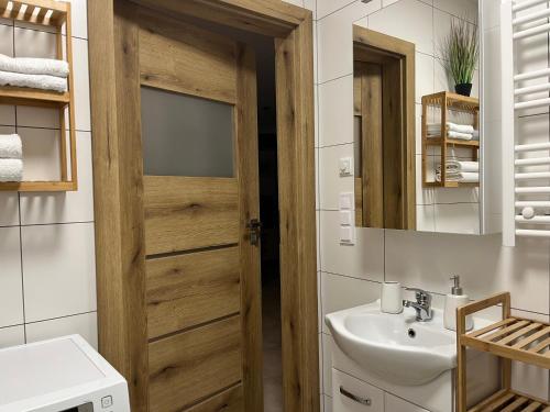 a bathroom with a wooden door and a sink at Czarno biały in Racibórz